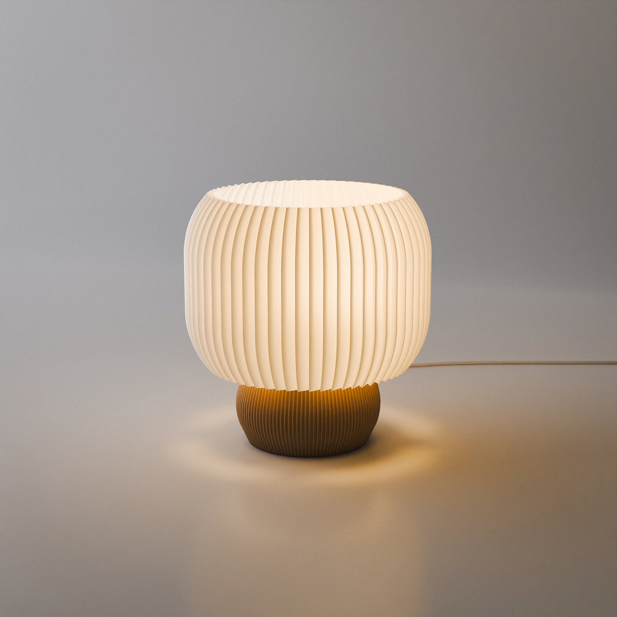 Lampa Hikari 02 aprinsă, lumină caldă ambientală, bază aurie, abajur alb pliseat