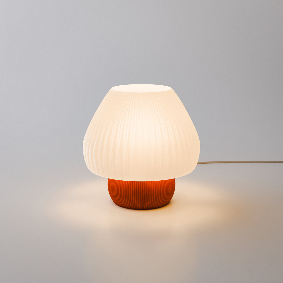 Lampa Hikari Mini aprinsă pe birou, atmosferă japoneză, bază terracotta și abajur alb pliseat